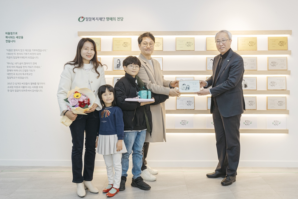컴패니언클럽 26ȣ 박성현 후원자(가운데)와 가족들이 밀알복지재단 정형석 상임대표로부터 위촉패를 받고 있다.